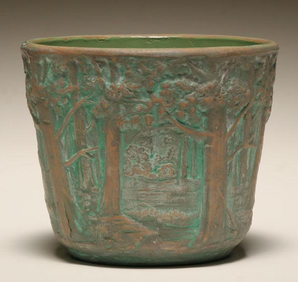 Appraisal: Art pottery jardiniere depicting a naturalistic wooded interior in relief