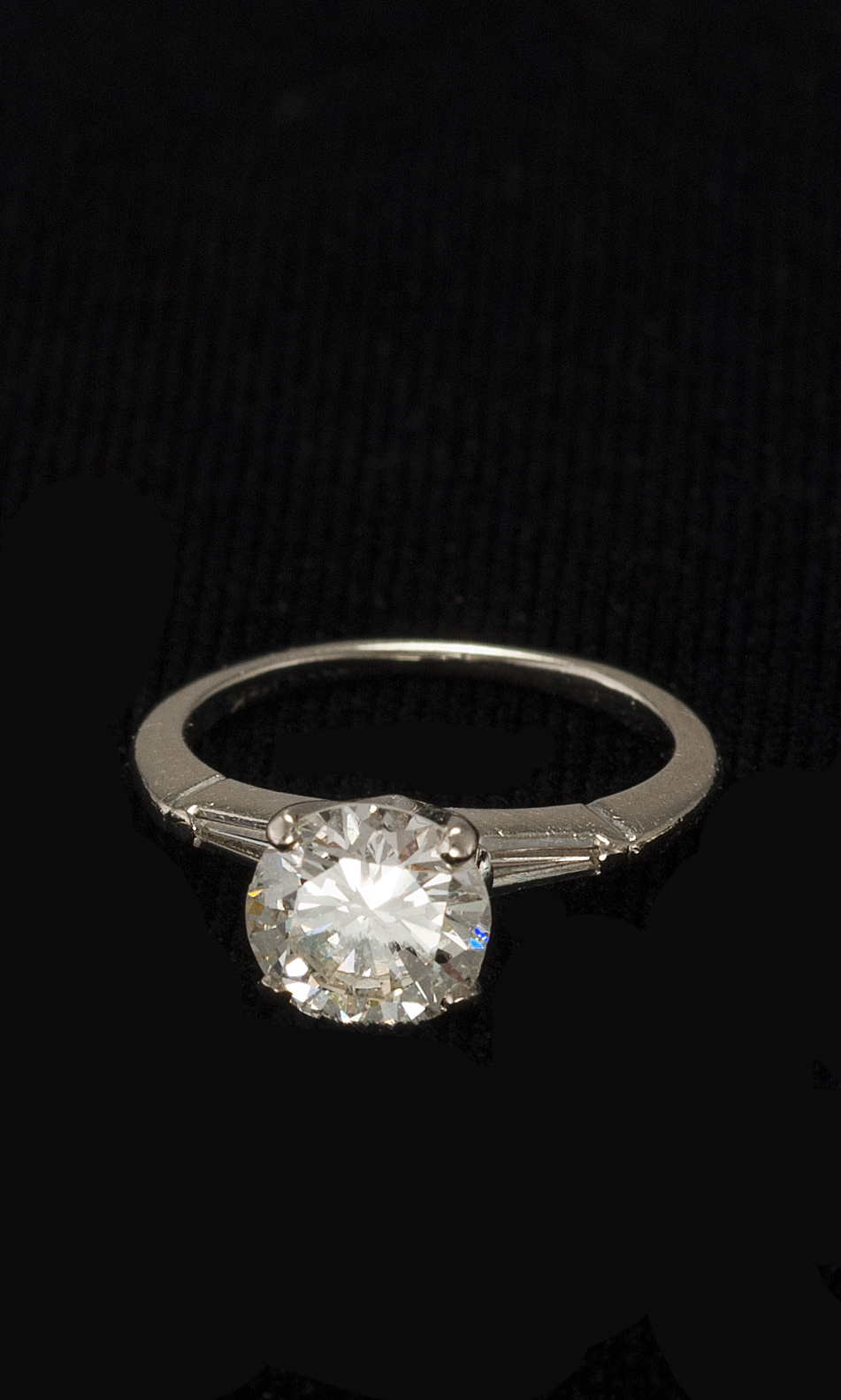 Appraisal: PLATINUM AND DIAMOND ENGAGEMENT RING Central diamond flanked by two