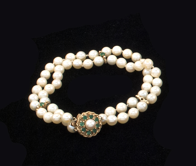 Appraisal: KT YELLOW GOLD AND EMERALD-MOUNTED DOUBLE-STRAND PEARL BRACELET With fifty-five