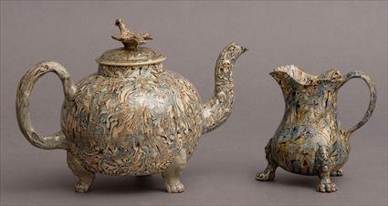 Appraisal: WHIELDON GRANITEWARE TEAPOT AND COVER AND TRIPOD CREAMER The spherical