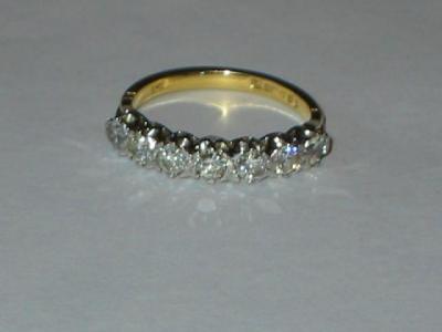 Appraisal: A DIAMOND HALF ETERNITY RING comprising seven brilliant cut diamonds