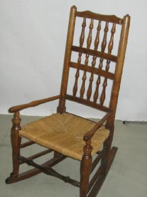 Appraisal: AN ASH SPINDLE BACK ROCKING CHAIR the arched top rail