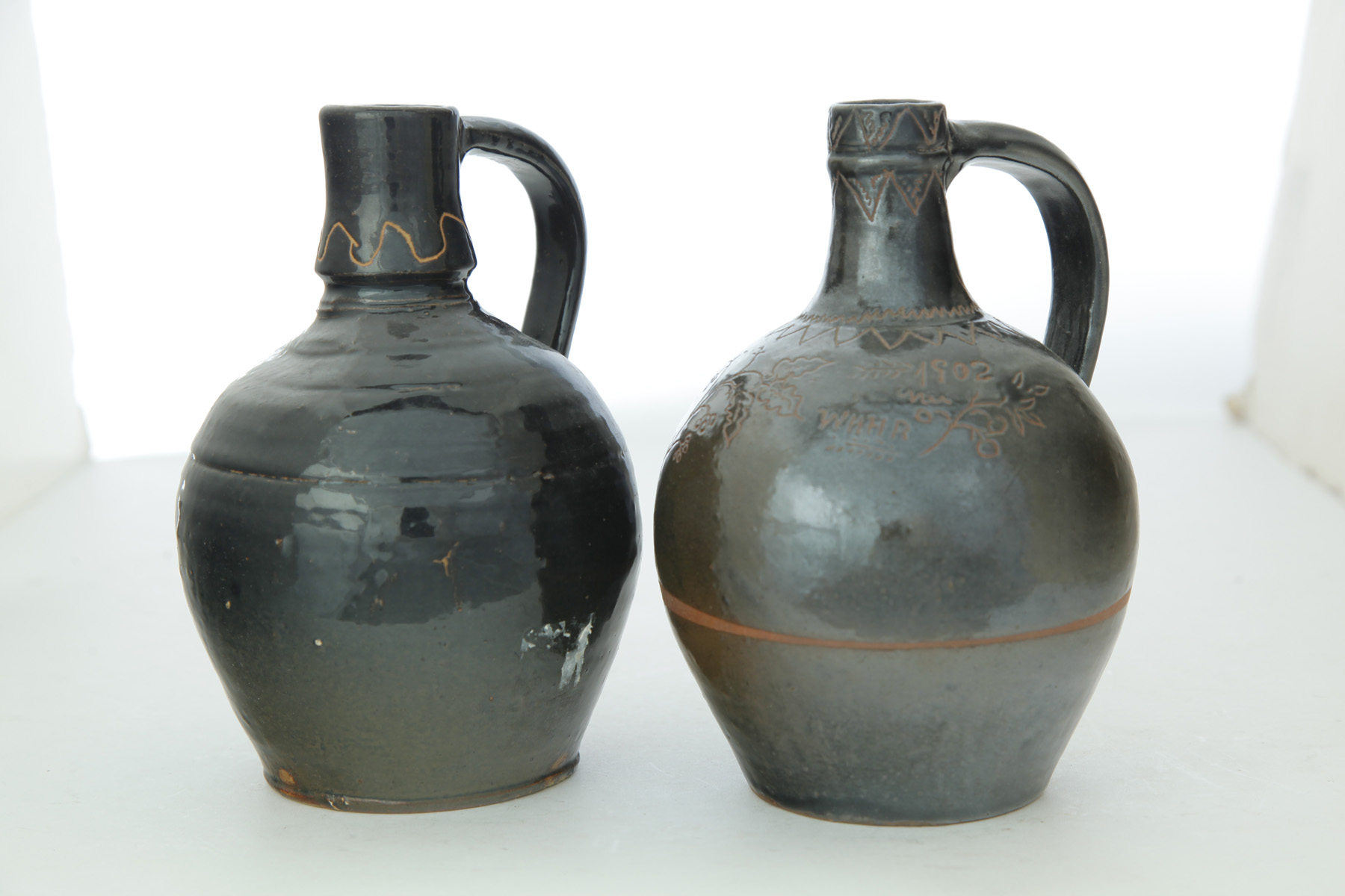 Appraisal: TWO OHIO SGRAFFITO-DECORATED STONEWARE JUGS Late th-early th century Of