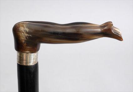 Appraisal: CARVED HORN-HANDLED CANE Carved as a nude bending over above