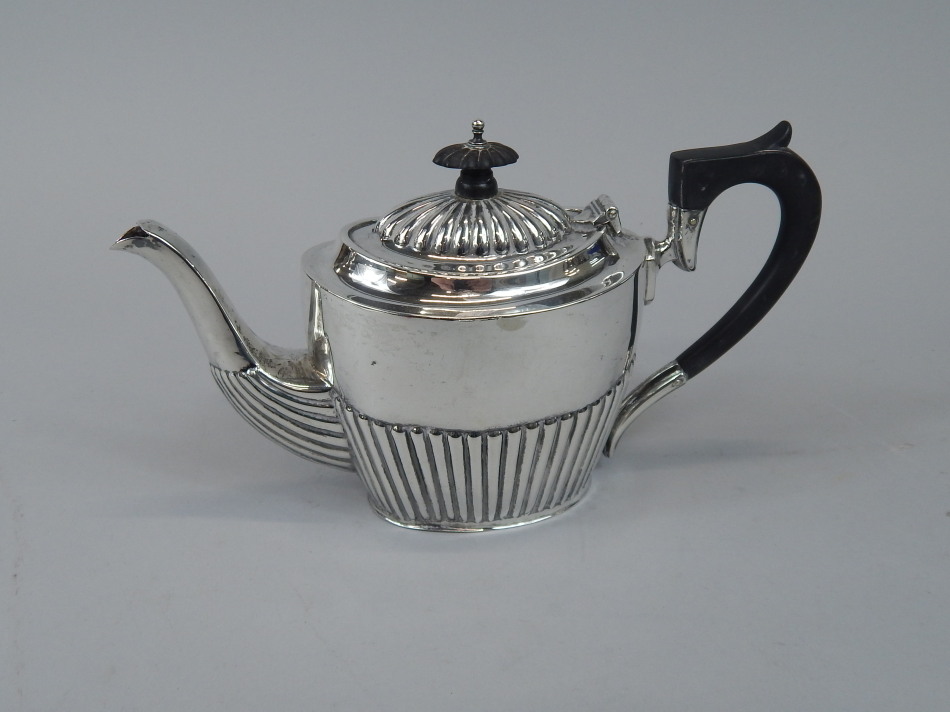 Appraisal: A silver part fluted tea for two sized teapot Chester