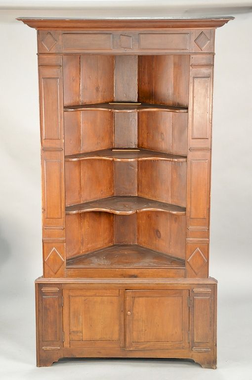 Appraisal: Primitive corner cupboard in two parts with raised panels and