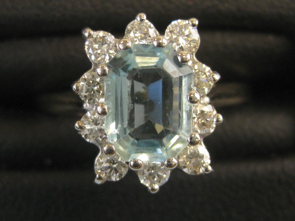 Appraisal: An Aquamarine and Diamond Cluster Ring the claw-set step-cut aquamarine