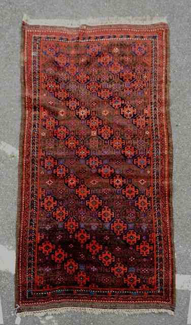 Appraisal: A BELOUCH BROWN GROUND RUG decorated seven diagonal rows of