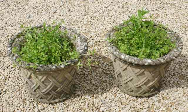 Appraisal: A PAIR OF WEATHERED COMPOSITION GARDEN URNS simulated lattice work