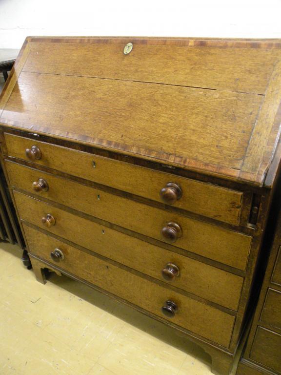 Appraisal: A George III oak and mahogany cross banded bureau with