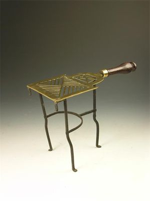 Appraisal: A th century pierced brass trivet with turned mahogany handle