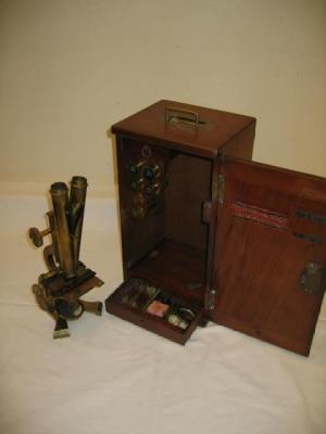 Appraisal: A LACQUERED BRASS BINOCULAR MICROSCOPE on twin pillared stand in