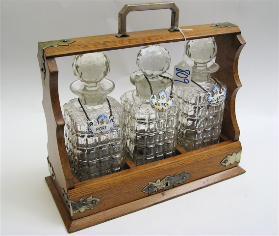 Appraisal: AN ENGLISH THREE-BOTTLE TANTALUS oak carrying case containing faceted cut