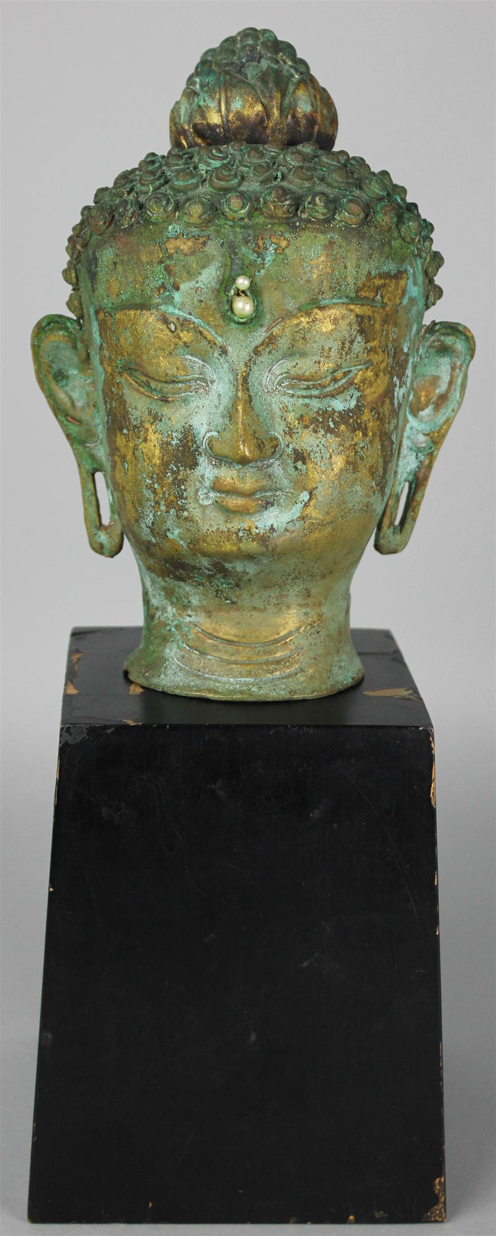 Appraisal: SOUTHEAST ASIAN BRONZE HEAD OF BUDDHA covered with a green