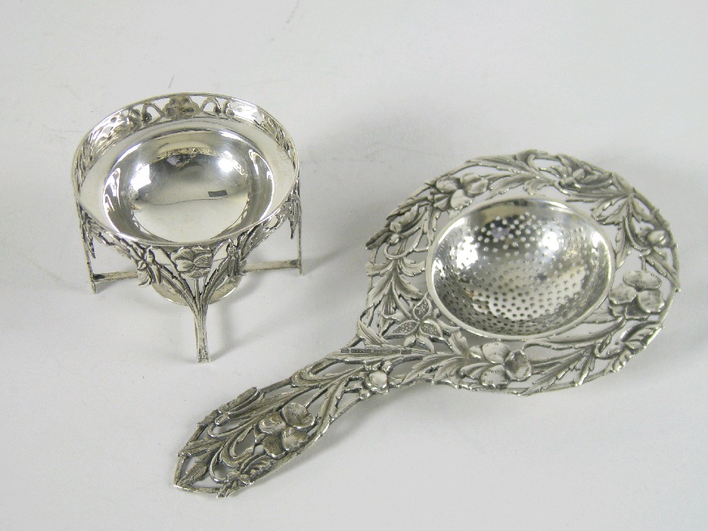 Appraisal: A Tea Strainer and Stand with pierced Art Nouveau style