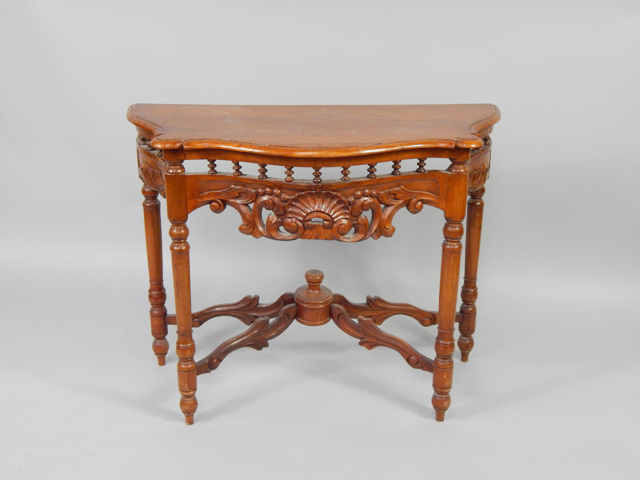 Appraisal: A Continental walnut serpentine side table with a carved shell