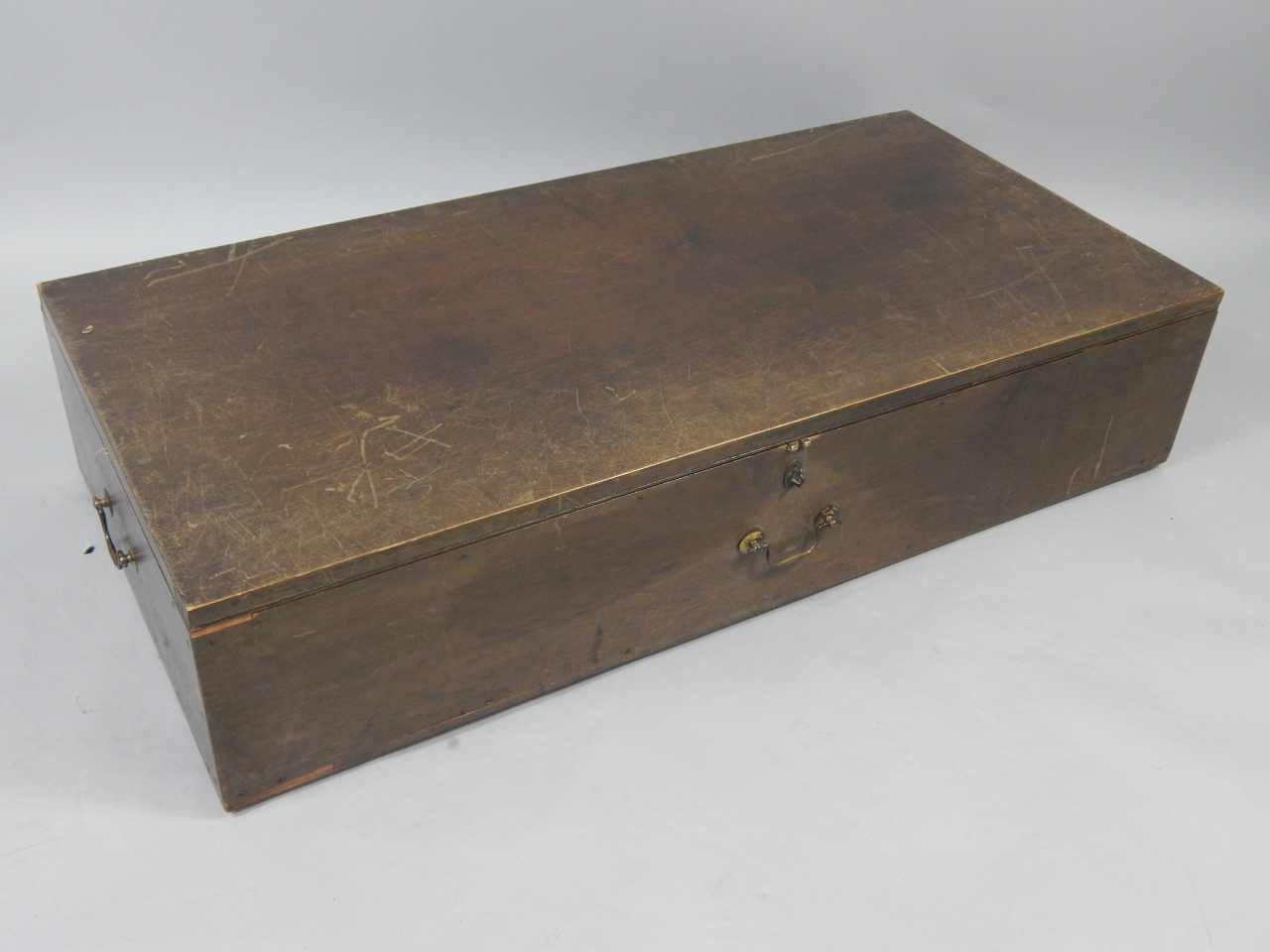 Appraisal: A stained pine trunk early thC with brass handles raised