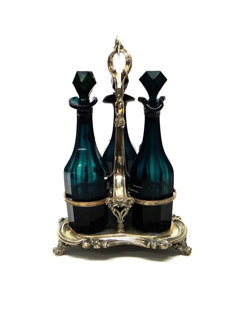 Appraisal: A Sheffield plated three bottle decanter stand the triform base