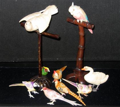 Appraisal: Tinted Ivory Bird Models th c Two well-carved perched birds