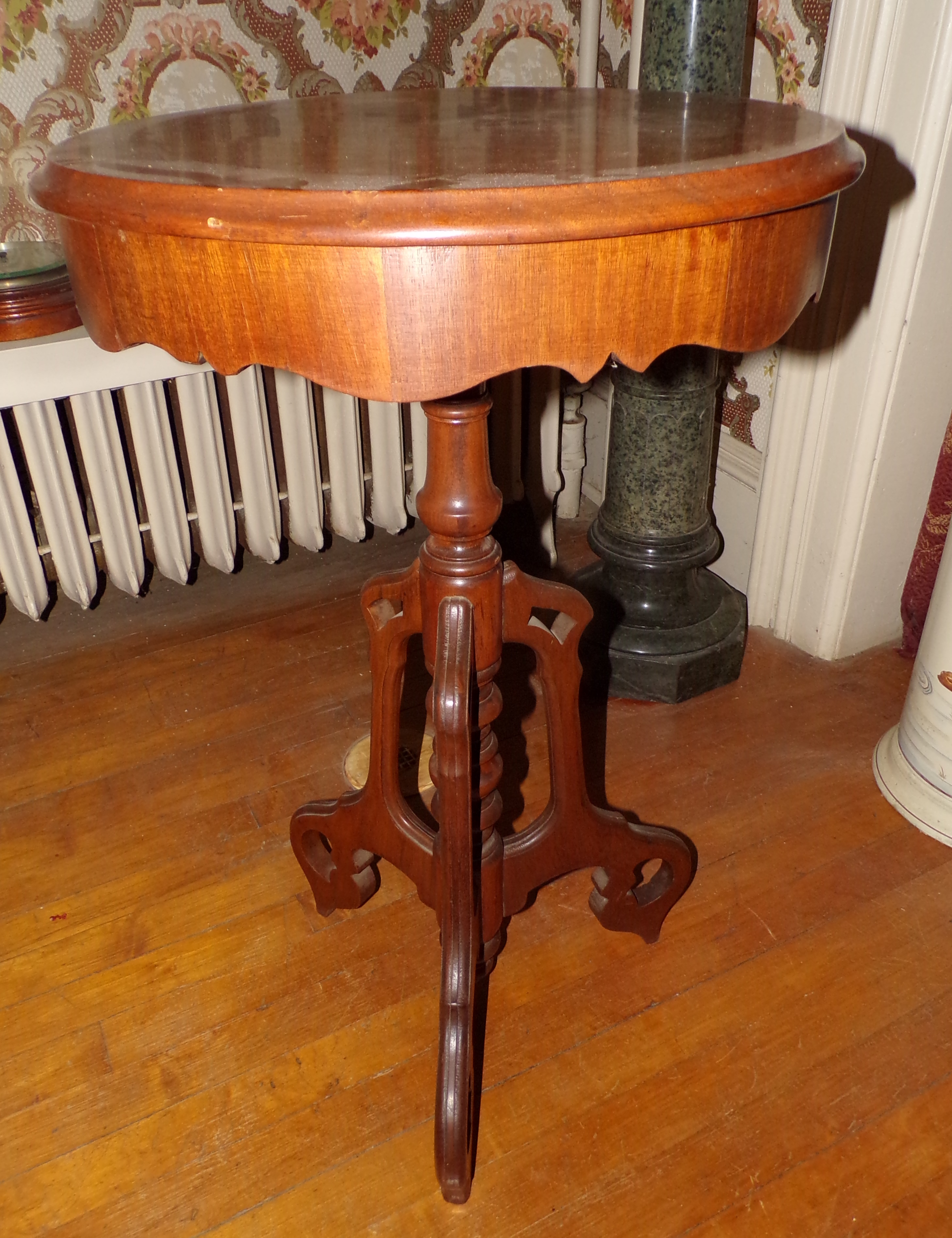 Appraisal: Walnut plant stand with carved skirt turned column tri-foot base