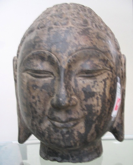 Appraisal: A SINO-TIBETAN STONE SCULPTURE head of Gautama Buddha with downcast