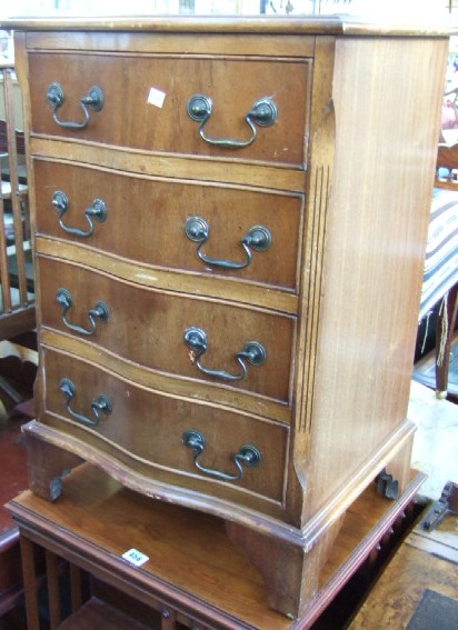 Appraisal: A th century small mahogany serpentine chest of four long