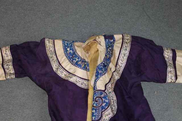 Appraisal: A CHINESE AUBERGINE SILK SURCOAT with embroidered sleeves and border