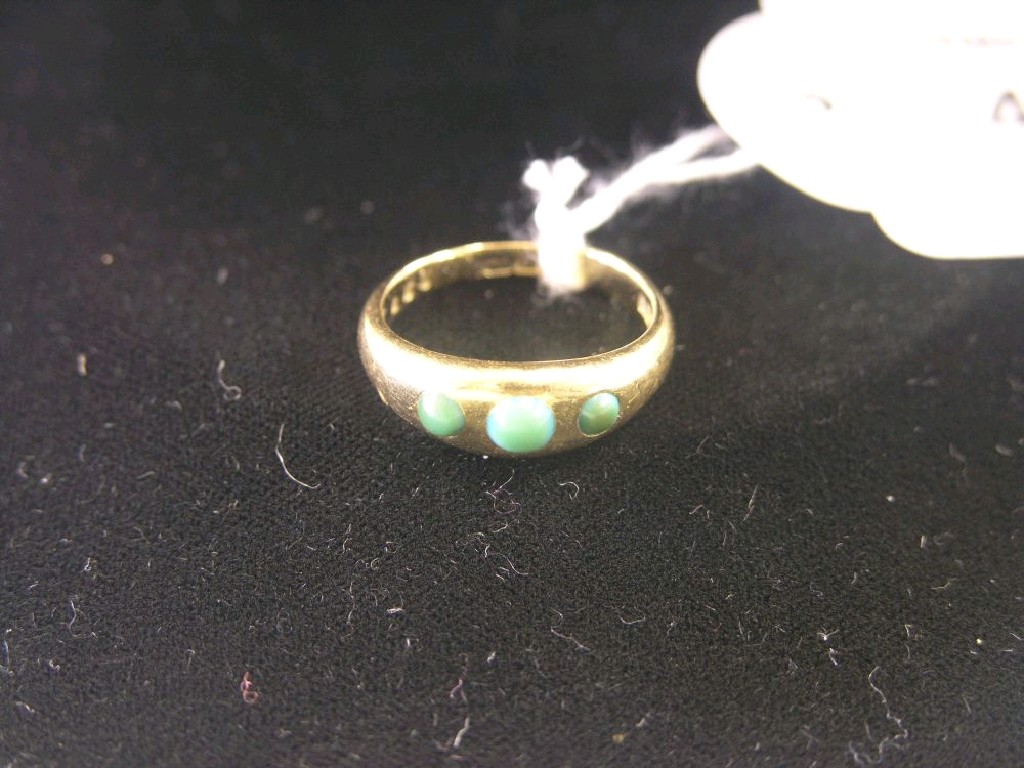 Appraisal: An ct gold ring gypsy-set with three jade-type stones ring