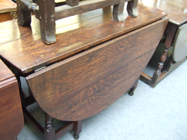 Appraisal: A part th century oak oval drop flap dining table