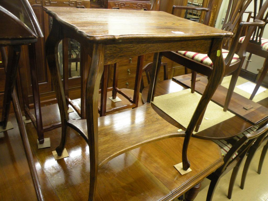 Appraisal: An Edwardian oak two tier table on shaped supports