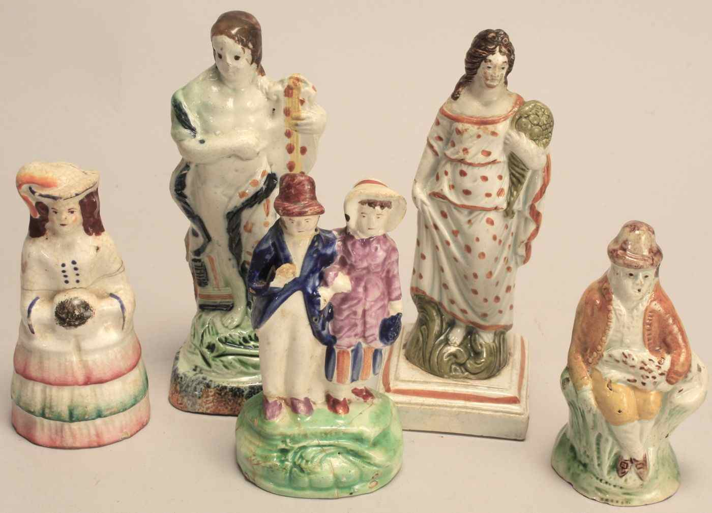 Appraisal: FIVE ENGLISH STAFFORDSHIRE FIGURES th CenturyMusician height a woman holding