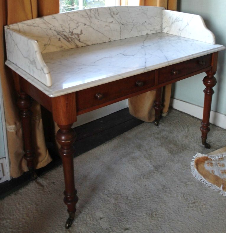 Appraisal: A Victorian mahogany washstand with marble tray top two frieze