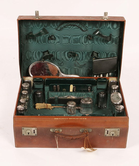 Appraisal: A VICTORIAN LEATHER TRAVELLING CASE fitted with various silver mounted