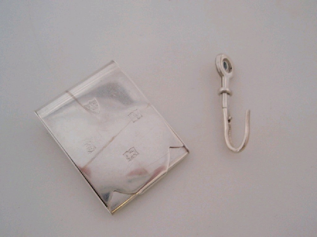 Appraisal: A silver napkin hook together with a silver match book