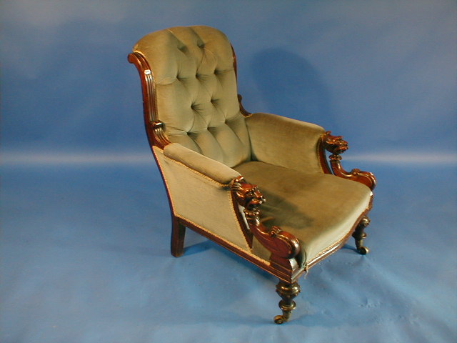 Appraisal: A Victorian mahogany deep upholstered armchair with stylised mask arms