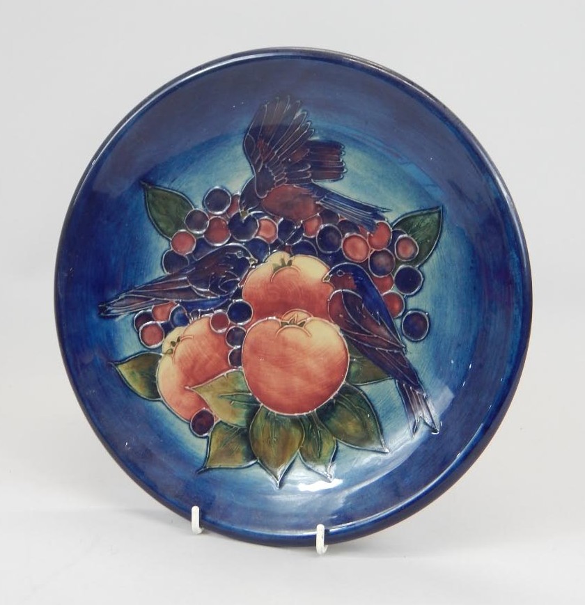 Appraisal: A Moorcroft plaque decorated with birds and fruit on a