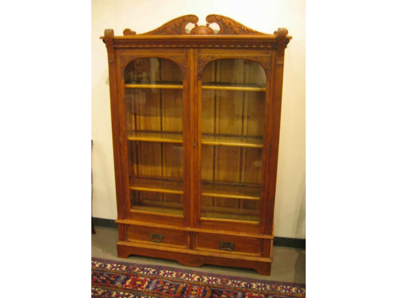 Appraisal: AMERICAN TH CENTURY WALNUT BOOKCASE Top with foliate carved scrolling