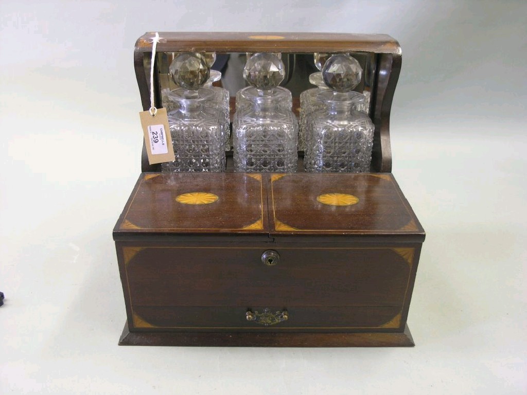 Appraisal: An Edwardian inlaid mahogany tantalus consisting of three hobnail cut