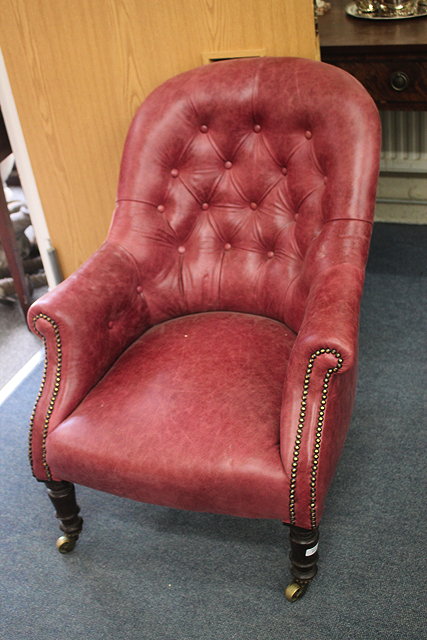 Appraisal: A VICTORIAN RED LEATHER BUTTON UPHOLSTERED ARMCHAIR with scrolling arms