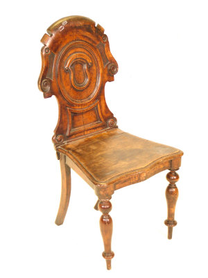 Appraisal: A Victorian oak hall chair the shield back above solid