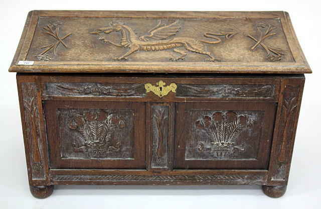 Appraisal: A SMALL OAK COFFER carved with Welsh emblems standing on