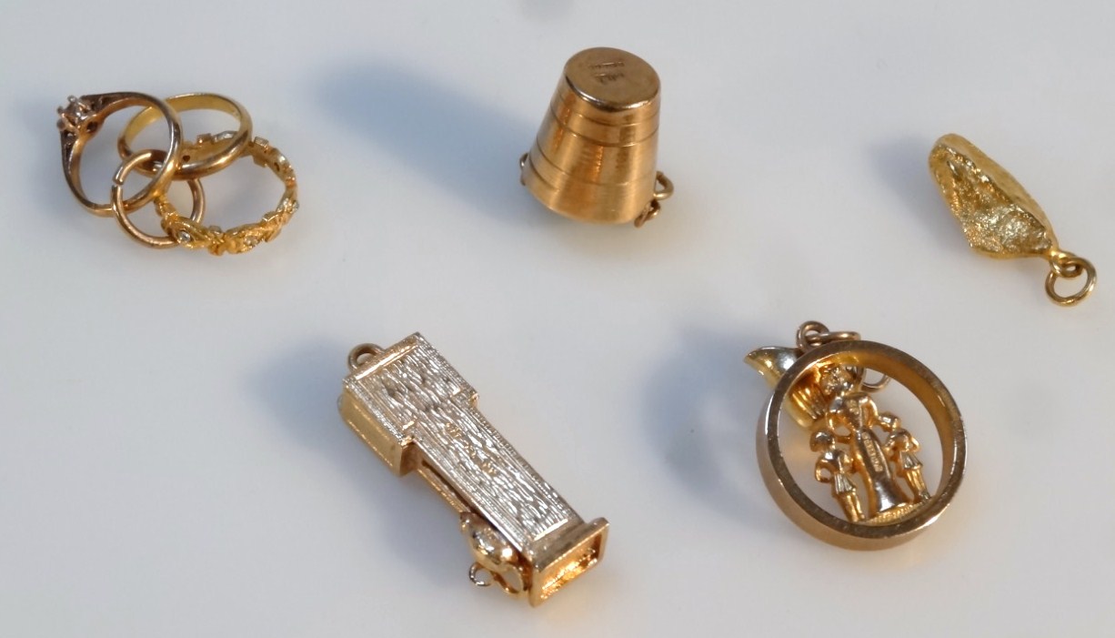 Appraisal: Various charms to include longcase clock cm high etc yellow