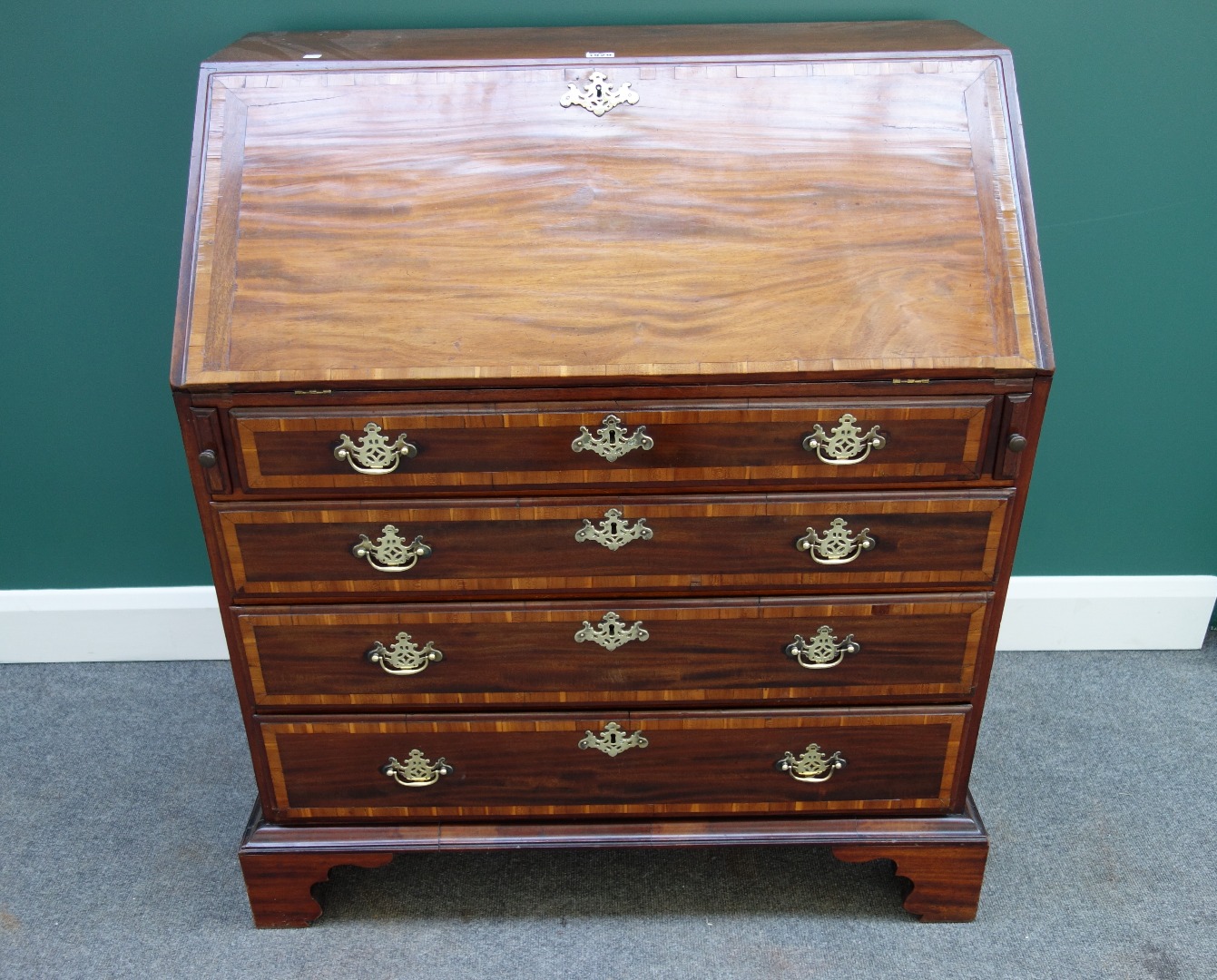 Appraisal: A George III fruitwood banded mahogany bureau the fall enclosing