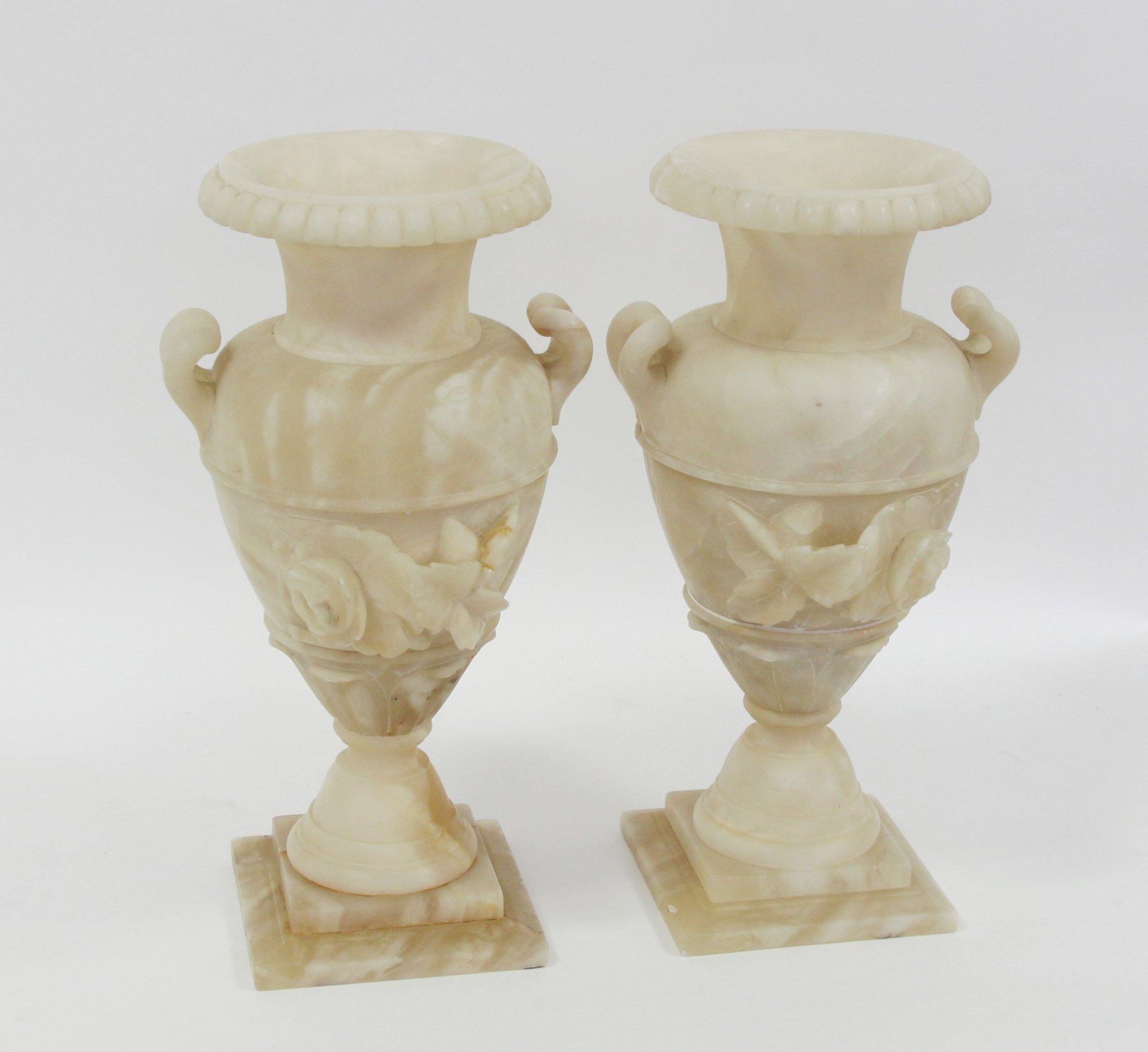 Appraisal: A pair of alabaster urns with carved floral motifs to