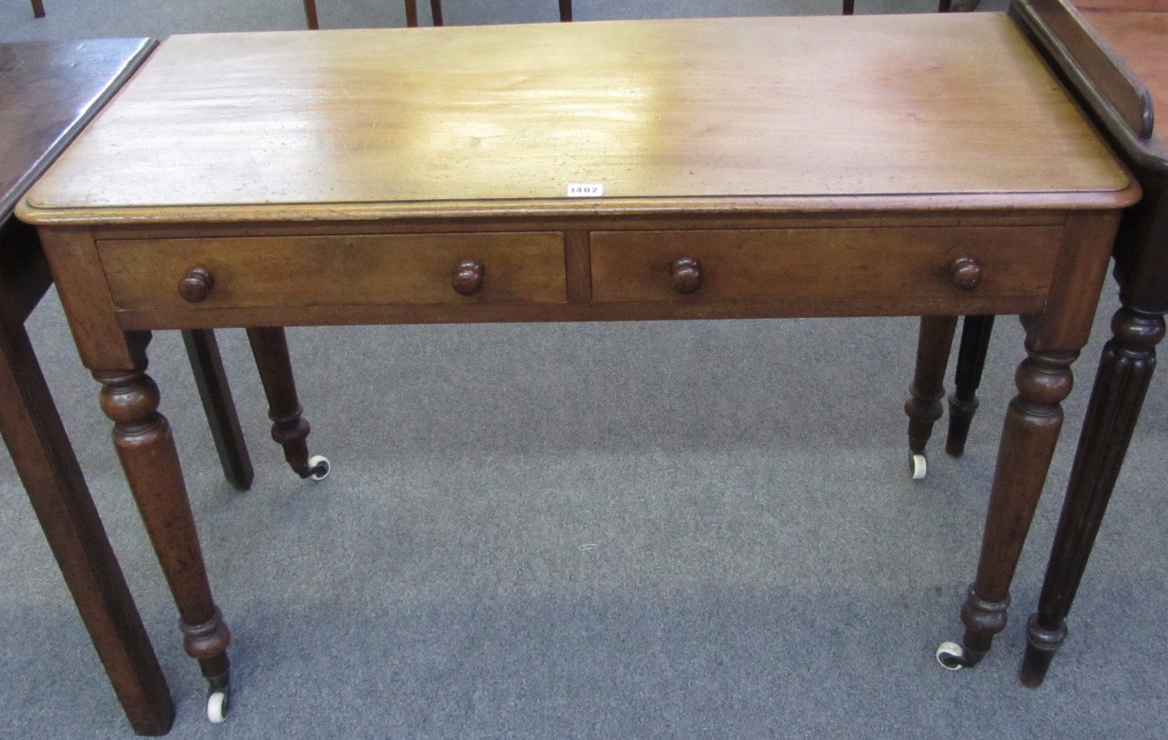 Appraisal: A th century mahogany two drawer writing table on turned