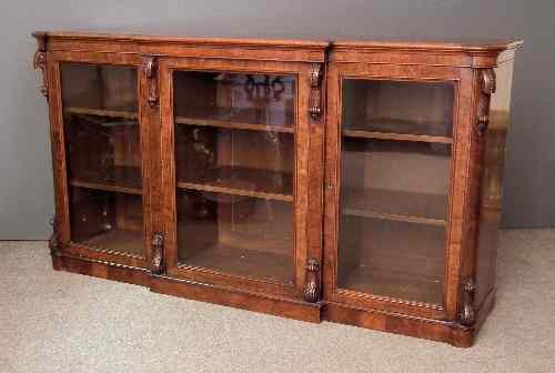 Appraisal: A Victorian figured walnut break front bookcase the top with