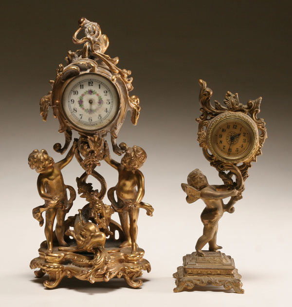 Appraisal: Two gilt metal cherub clocks ornate Victorian clock held aloft