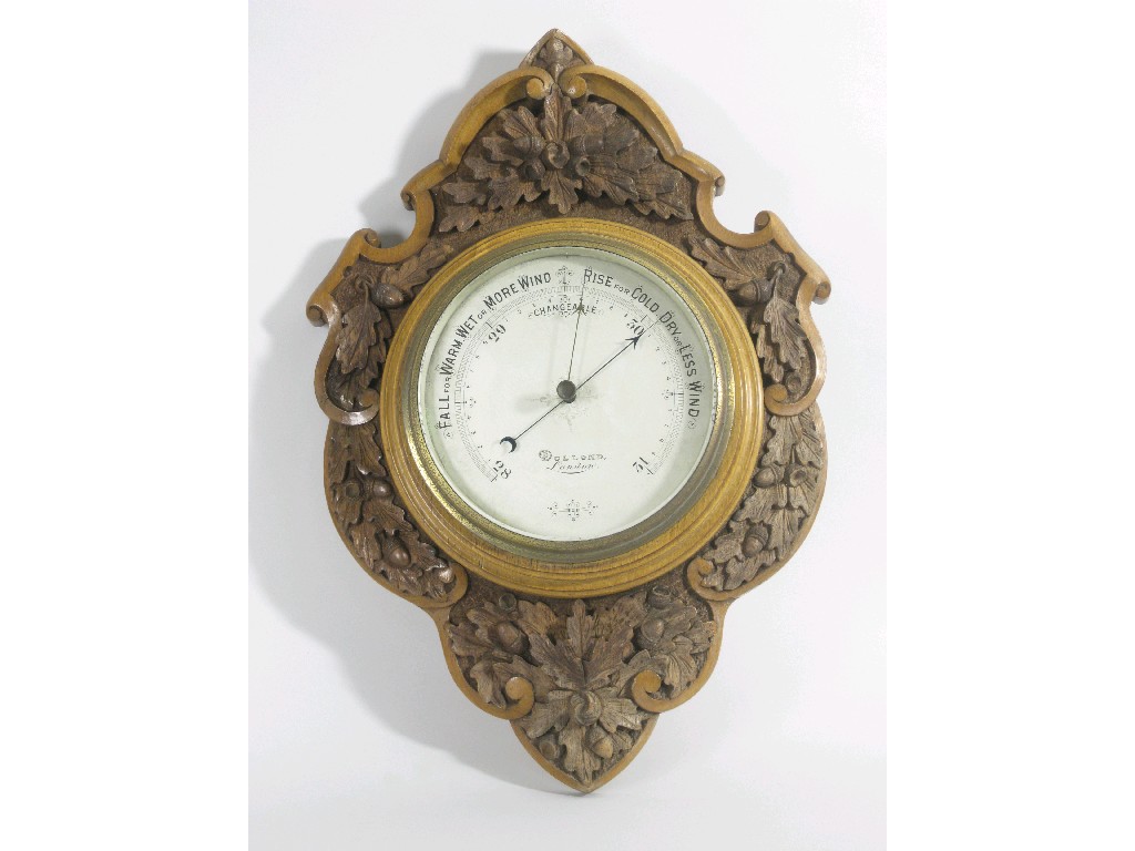 Appraisal: A late Victorian carved oak cased circular Aneroid Barometer with