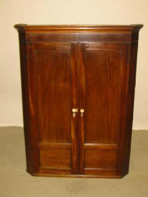 Appraisal: A MAHOGANY CORNER CUPBOARD with moulded cornice over plain frieze