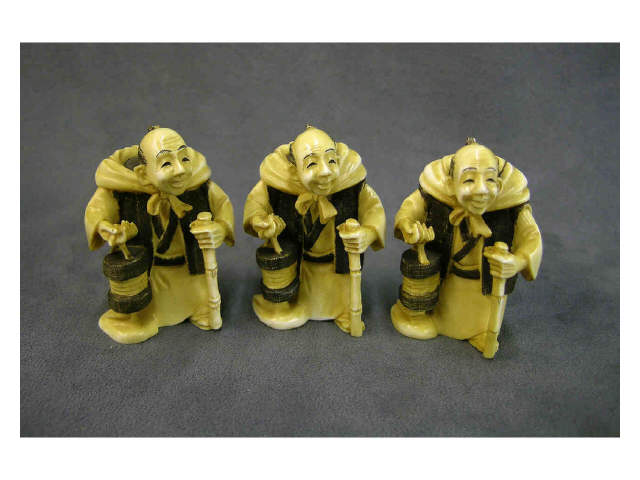 Appraisal: Three partially stained ivory netsuke all of a man with